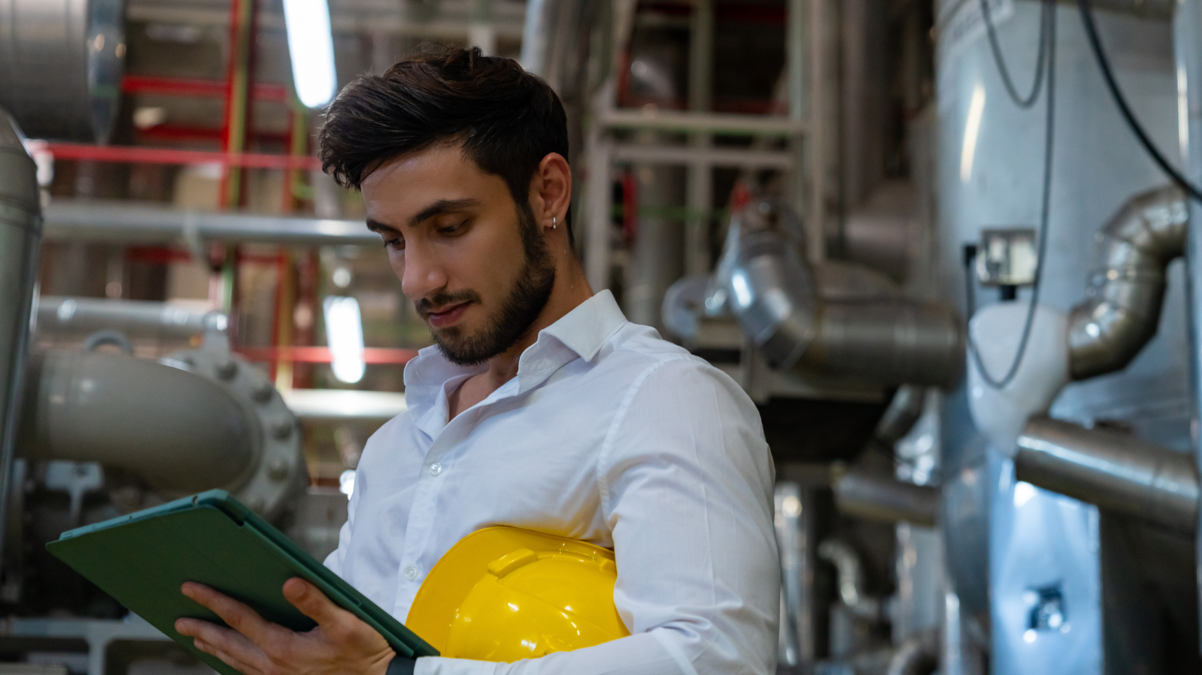An engineer in a factory controls a Voltalis demand response system with tablet.