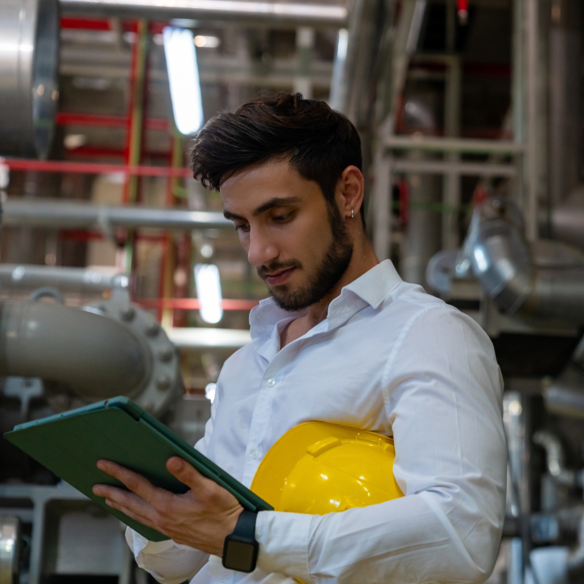 An engineer in a factory controls a Voltalis demand response system with tablet.